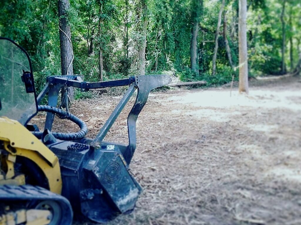 Skid steer mulching forest floor where land was cleared