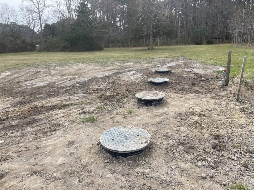 Two septic tanks burried with manhold covers exposed during septic tank repair process